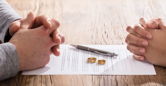 divorcing couple with paper and rings