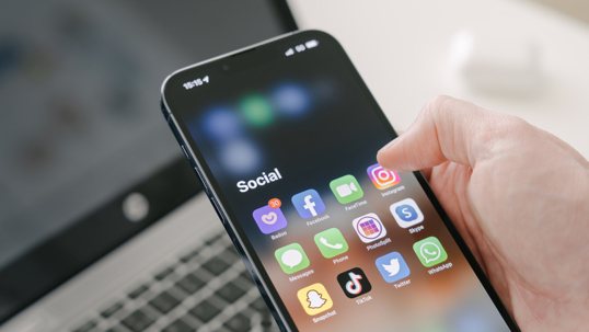 person on phone looking at social media apps